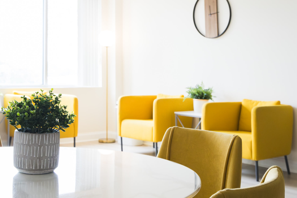 The Kuehnel Psychological Services waiting area, with yellow armchairs and a table by the window