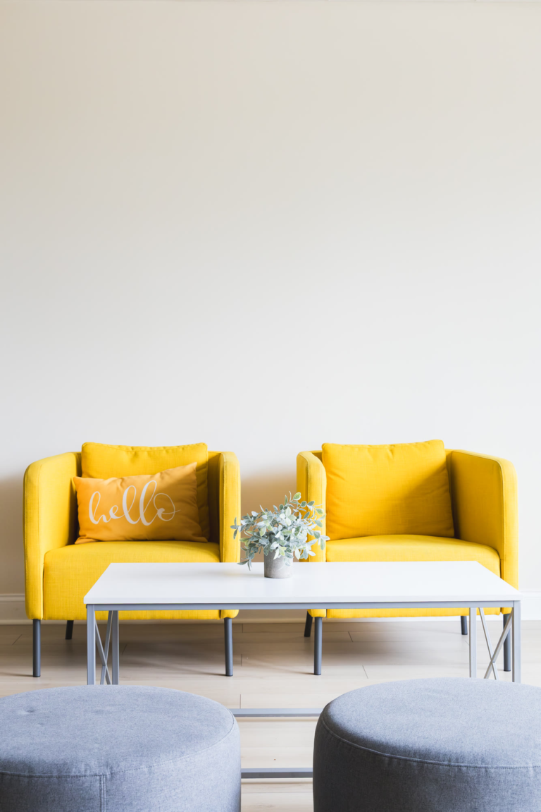 Two yellow armchairs and a coffee table in the Kuehnel Psychological Services waiting area